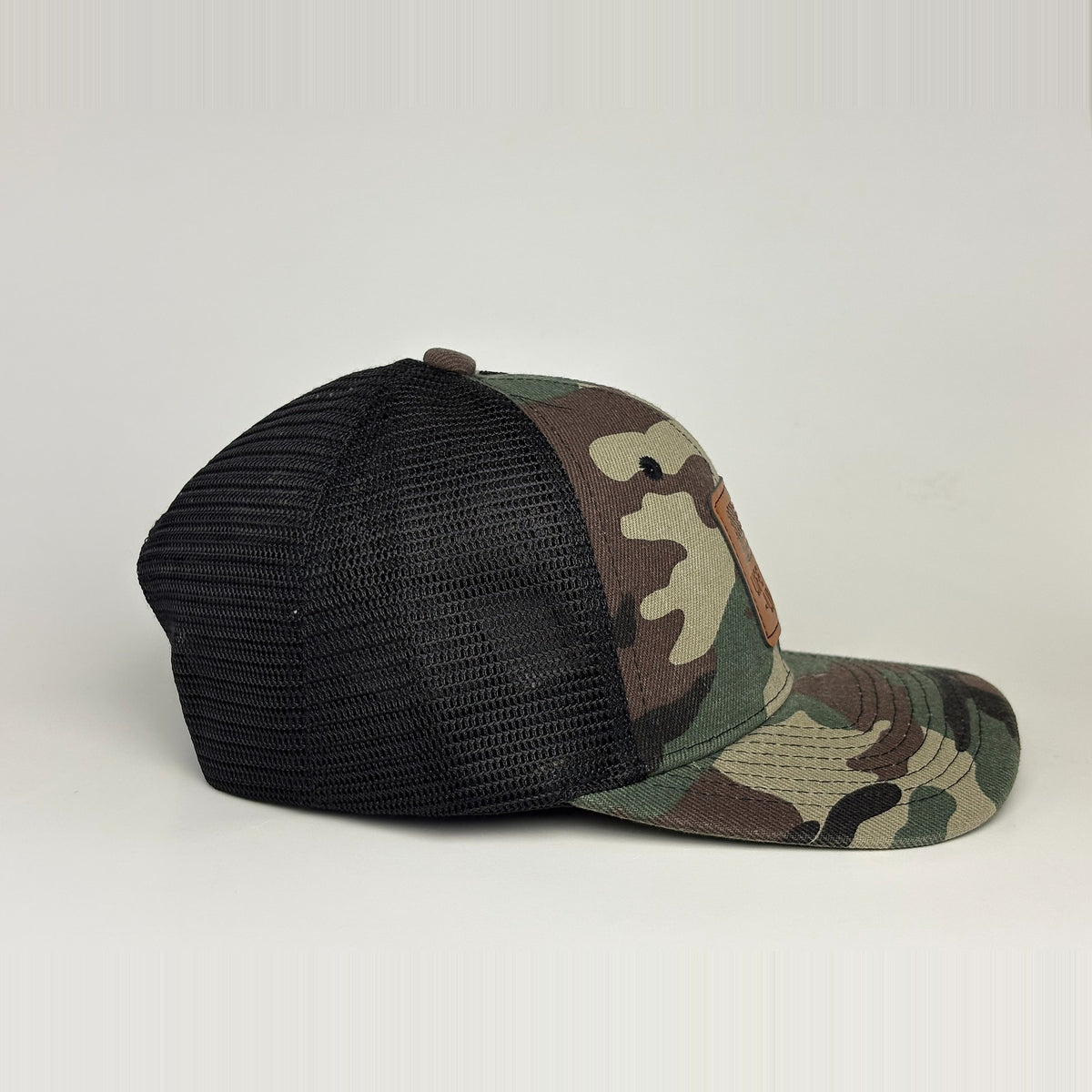 Camo trucker hat side profile - traditional woodland pattern with black mesh back