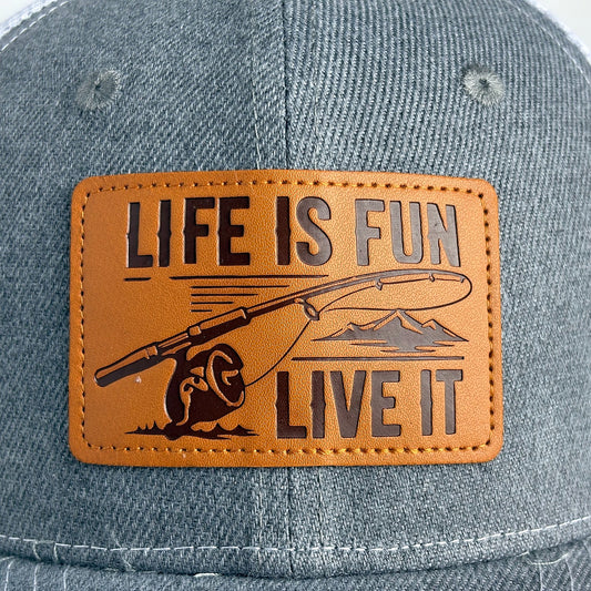 Tan leather patch with Life Is Fun Live It fishing rod logo close-up