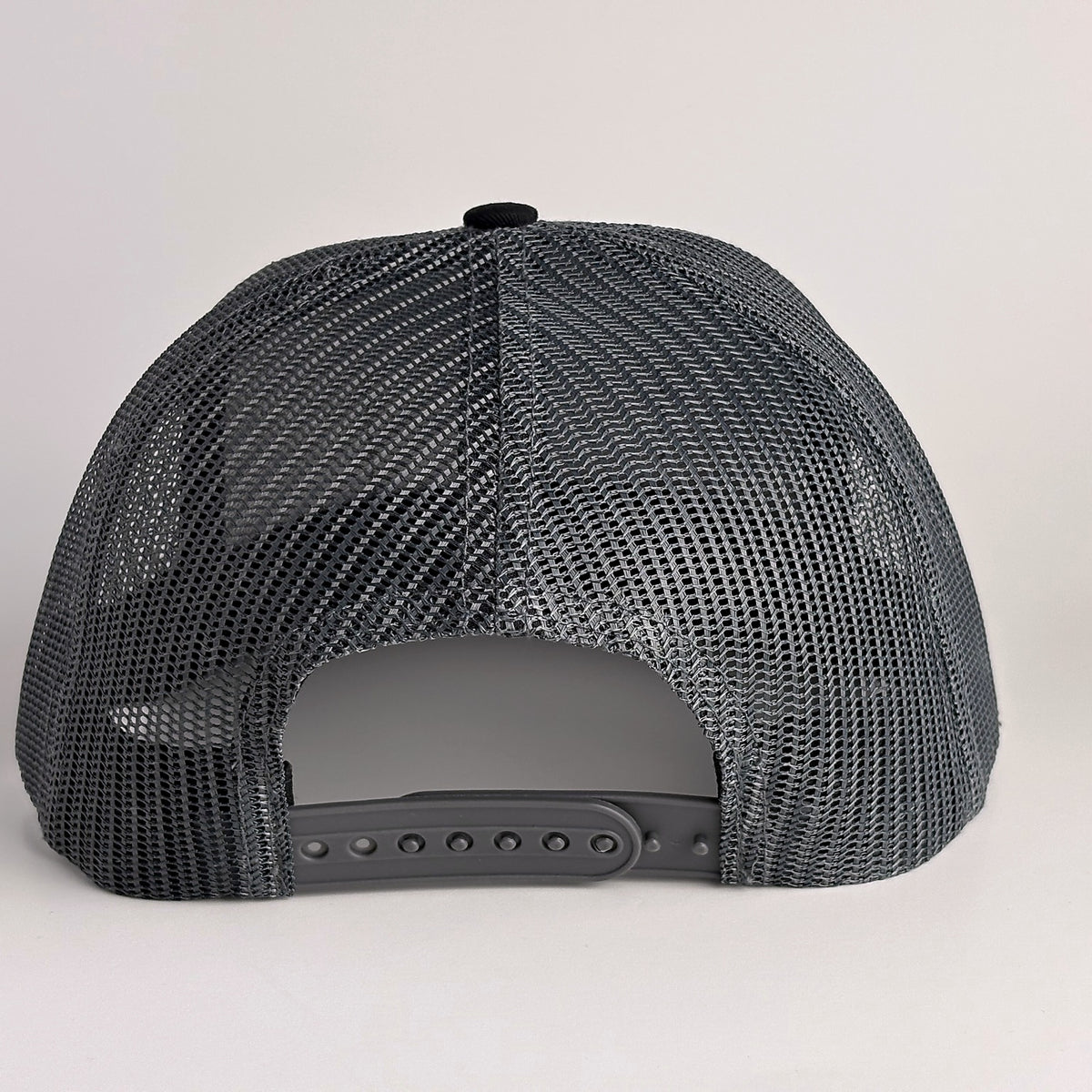 Black mesh back with snapback closure on trucker hat