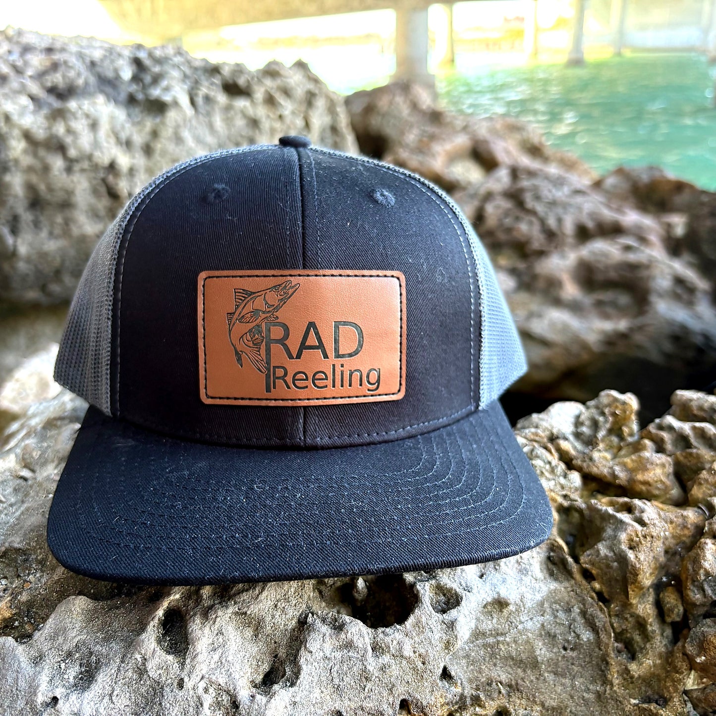 Rad Reeling snook fishing hat on rock near water lifestyle shot