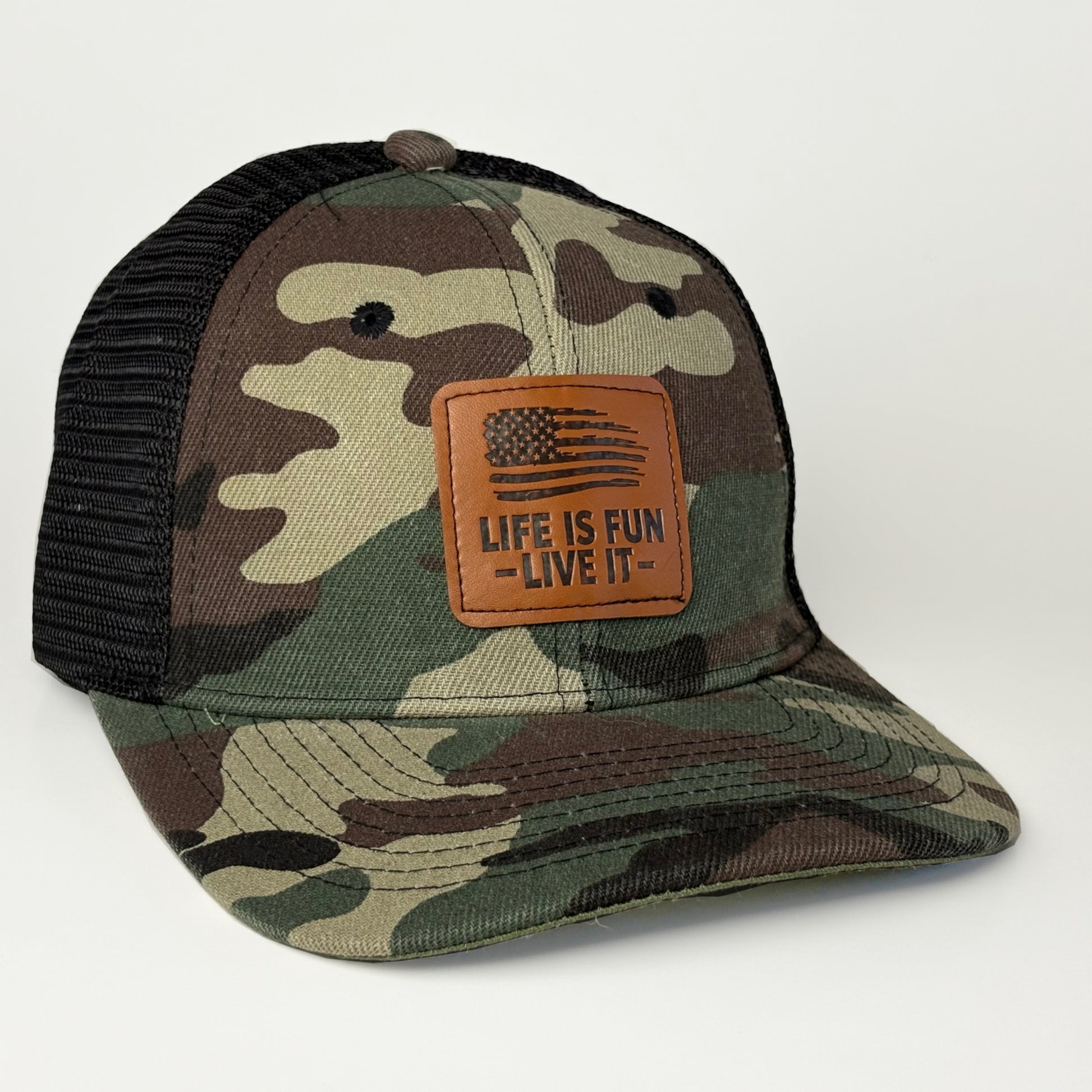 Camo trucker hat with American flag leather patch - Life Is Fun Live It front angle view