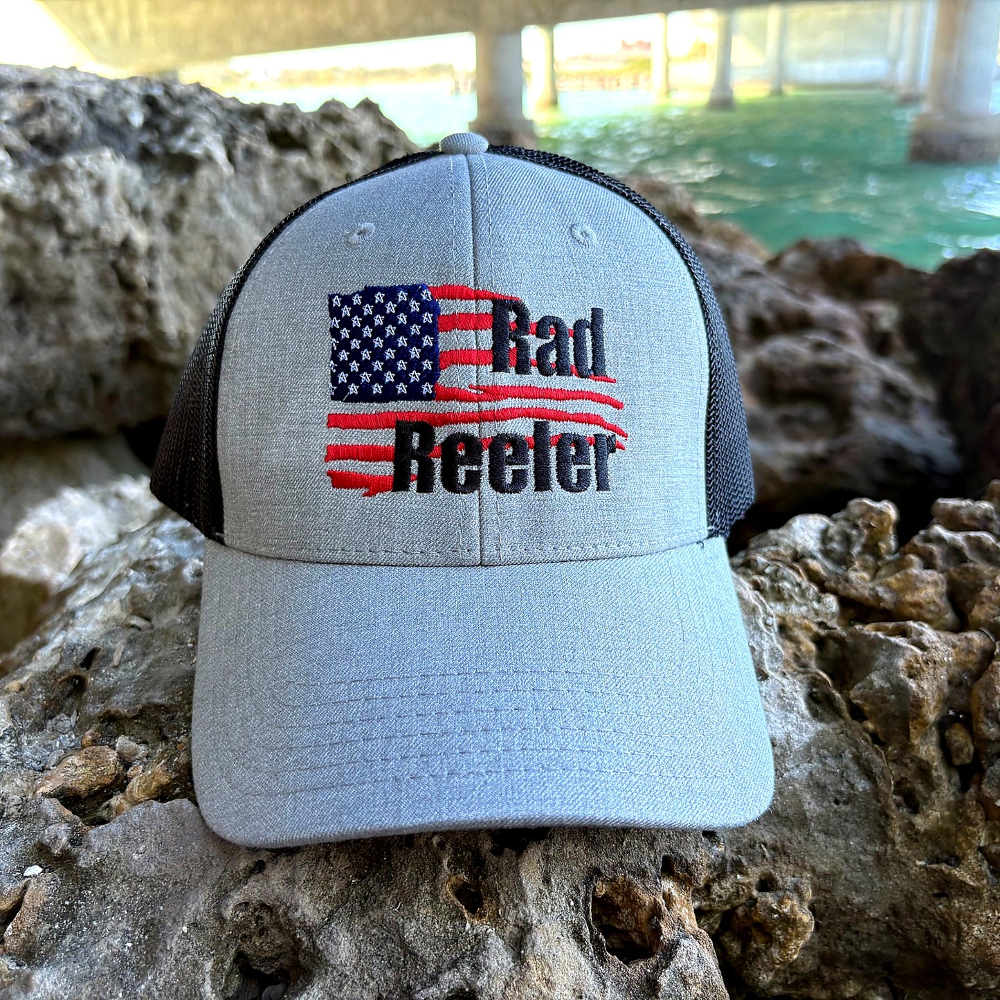 Rad Reeler American flag fishing hat on rock near water lifestyle shot