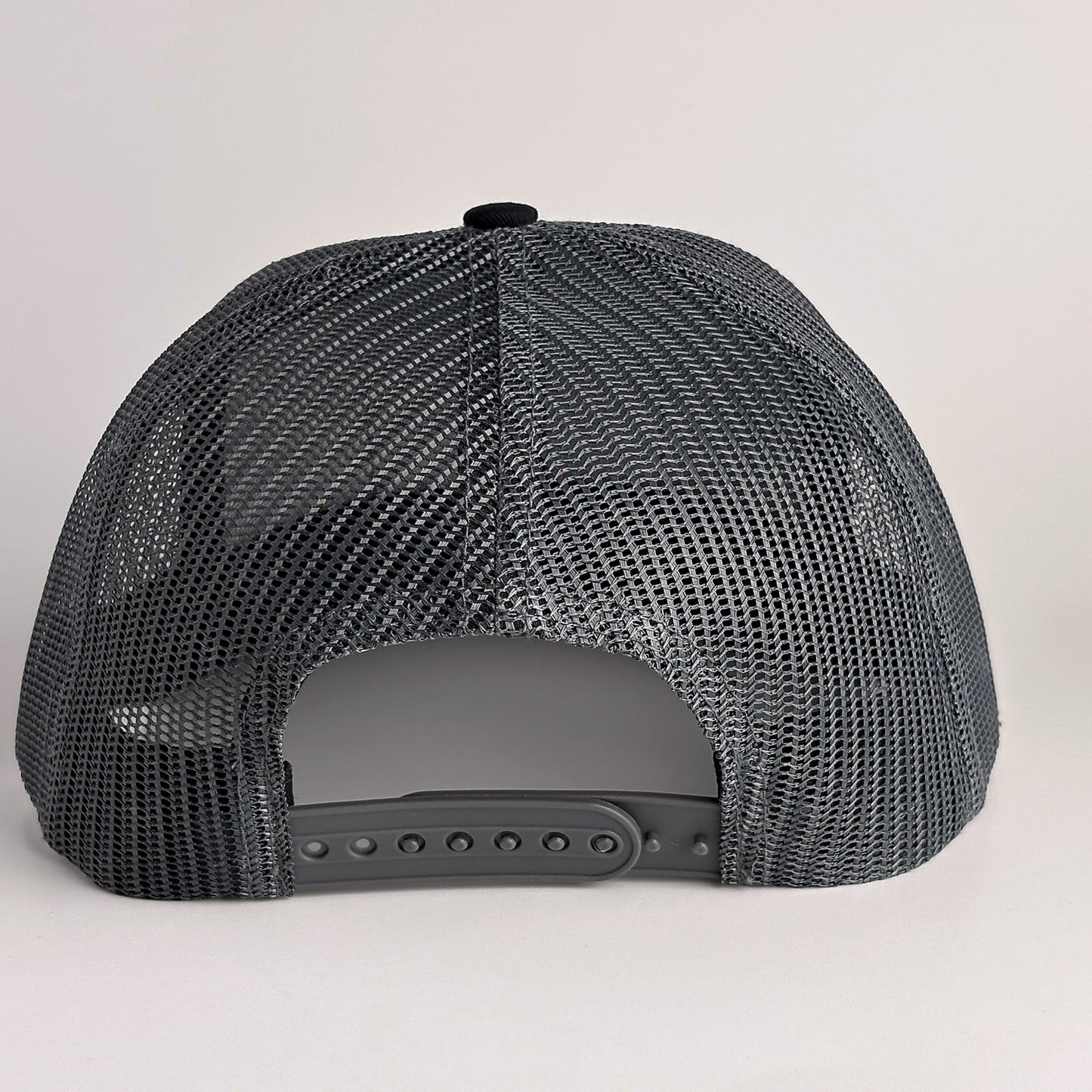 Black mesh back with snapback closure on trucker hat
