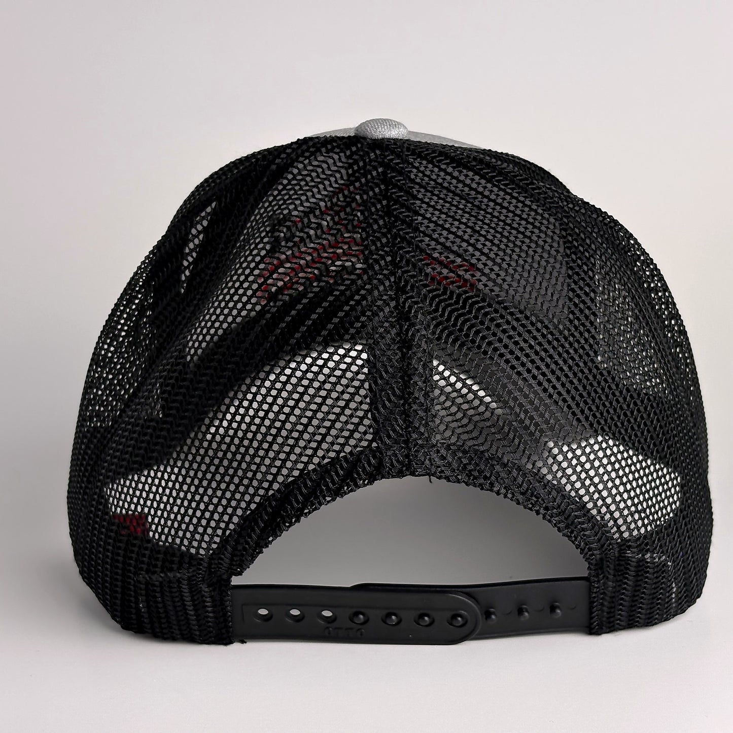 Charcoal grey mesh back with snapback closure on trucker hat