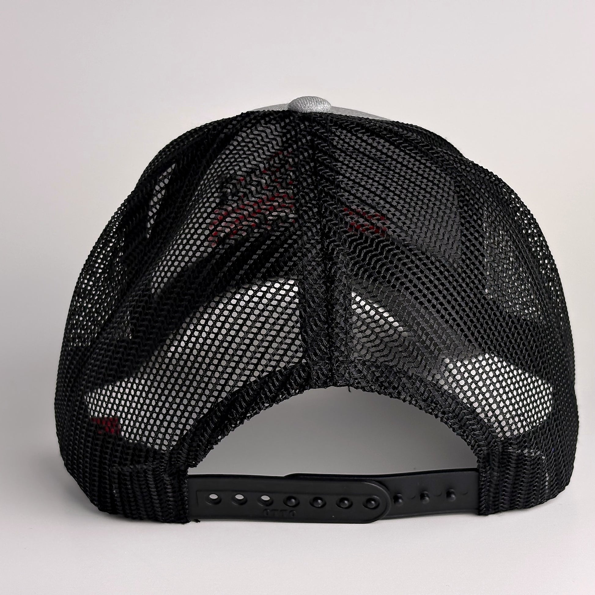 Charcoal grey mesh back with snapback closure on trucker hat