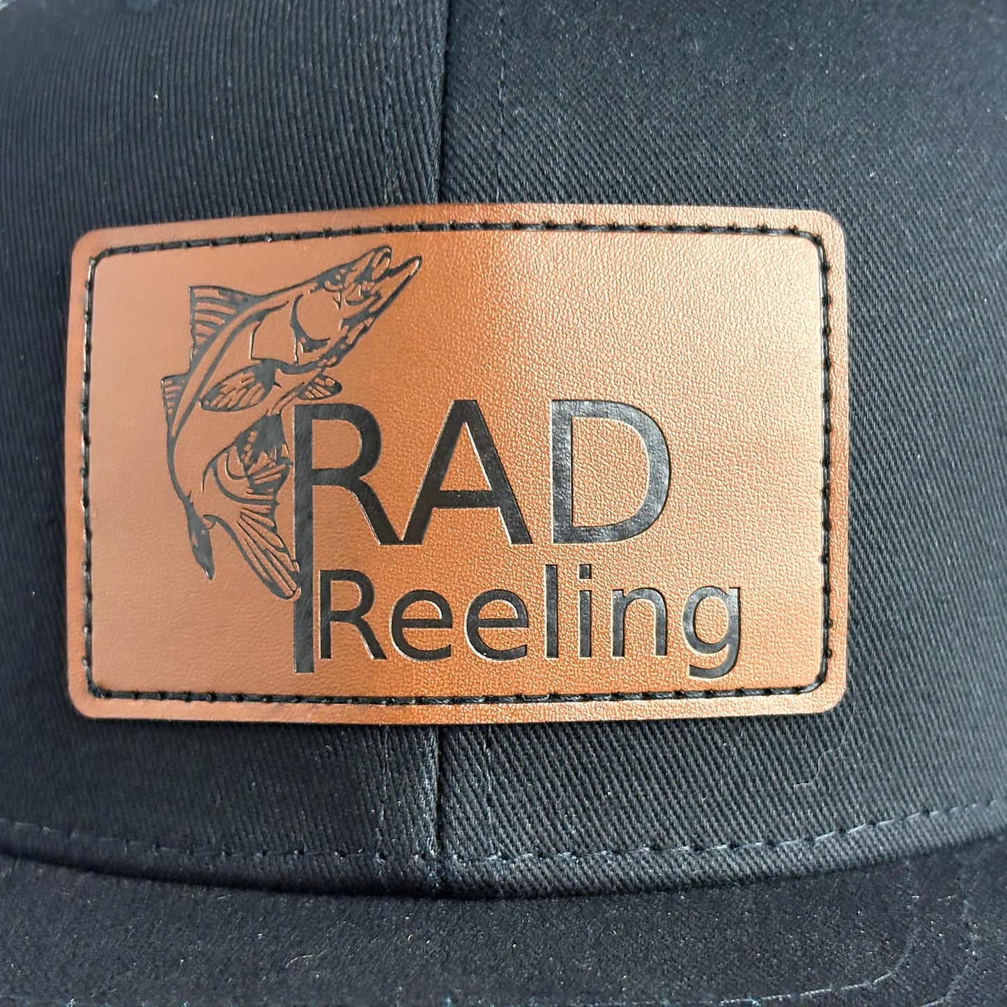 Tan leather patch with Rad Reeling snook fish logo close-up