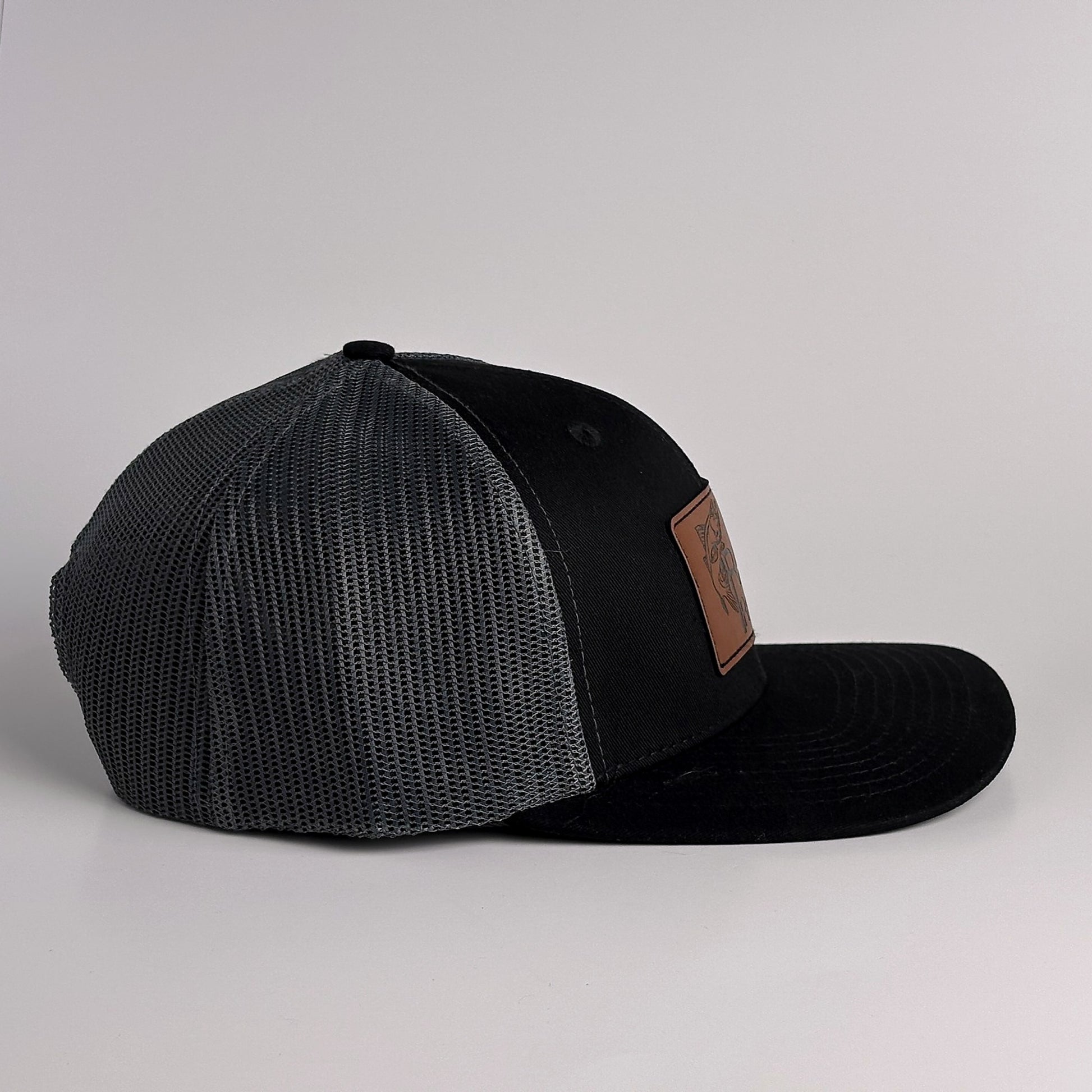 Black and charcoal grey mesh trucker hat with snapback side view
